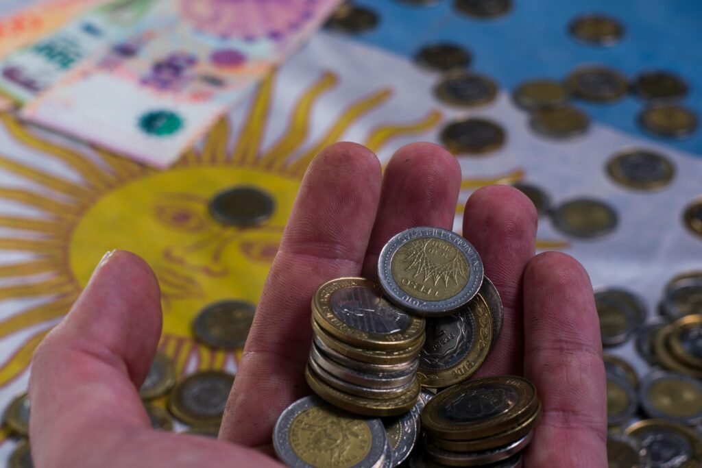 Mano sosteniendo monedas como símbolo de ahorro y control del dinero para salir de deudas